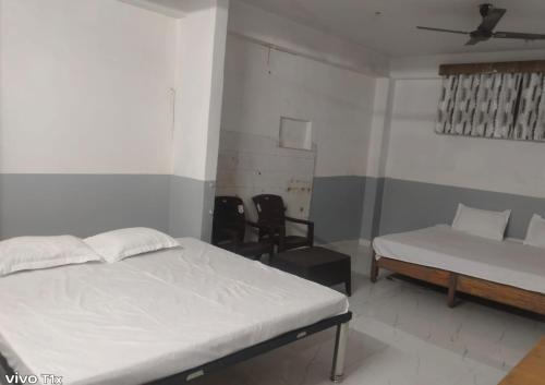 a bedroom with a bed and a couch and a chair at Comfi Stay Hotel Bhopal in Bhopal