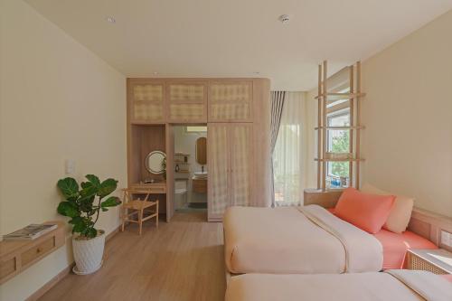 a bedroom with a bed and a couch in a room at The Gardener by WeDalat in Da Lat