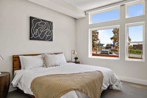 a white bedroom with a bed and a window at Lofted Living | Espadin LoHi in Denver