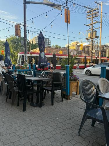 a group of tables and chairs on a city street at Private Balcony Studio Apartment for 5 People at Queen Street Downtown in Toronto