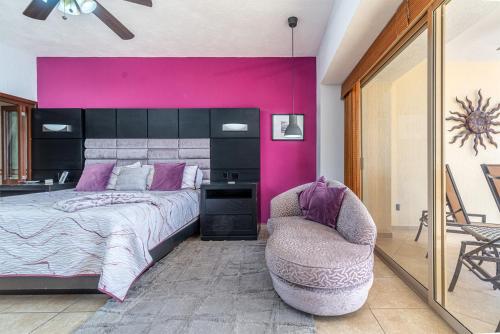 a bedroom with a large bed and a chair at Viva Beach Life Comfortable Oceanfront in Puerto Peñasco