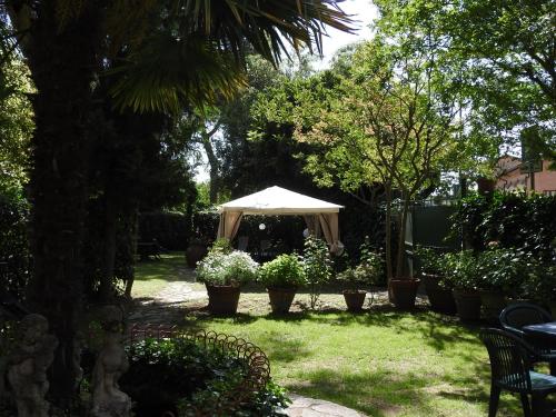 a garden with a white umbrella in the grass at Hotel Moderno in Siena