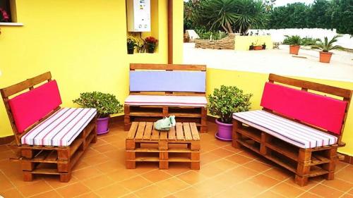 3 sillas y una mesa en un patio en AltaMarea, en Stintino