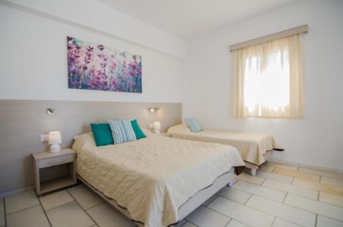 a bedroom with two beds and a window at Brother's Hotel in Ios Chora
