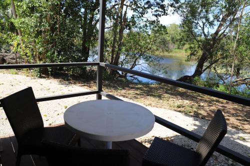 a table and chairs on a balcony with a view of a river at Mt Bundy Station in Adelaide River