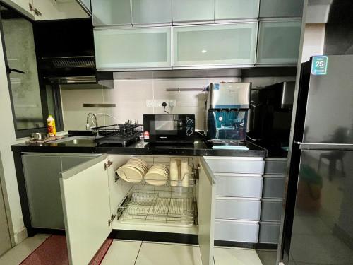 eine Küche mit offenem Geschirrspüler mit Mikrowelle in der Unterkunft 3room condo Almyra Residence Puteri Bangi in Kajang