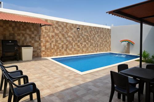 a swimming pool in a patio with chairs and a table at Casa con piscina cerca al aeropuerto in Malambo