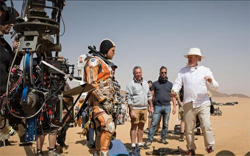 a group of men standing next to a camera in the desert at The bubble camp in Aqaba