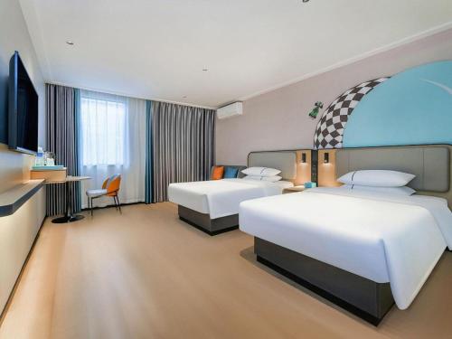 une chambre d'hôtel avec deux lits et une télévision dans l'établissement City Comfort Inn Chongqing Shiqiao Plaza Metro Station, à Sha-p'ing-pa