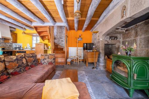 a living room with a couch and a fireplace at Gîte Le Moulin du Chambon 6/8 pers in Les Bessons