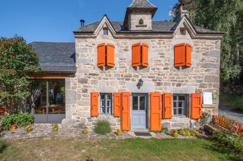 an old stone house with orange shutters at Gîte Le Moulin du Chambon 6/8 pers in Les Bessons