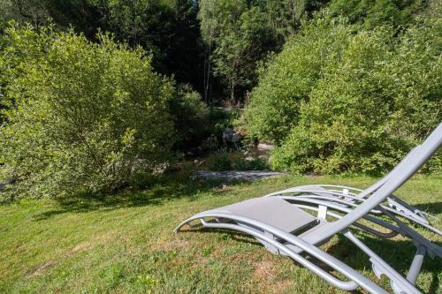 a chair laying on the grass in a field at Gîte Le Moulin du Chambon 6/8 pers in Les Bessons