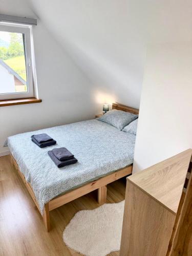 a bedroom with a bed with two towels on it at Domki Potok - Noclegi Bieszczady in Stefkowa