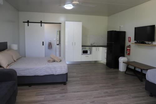 a living room with a bed and a kitchen at Mt Bundy Station in Adelaide River