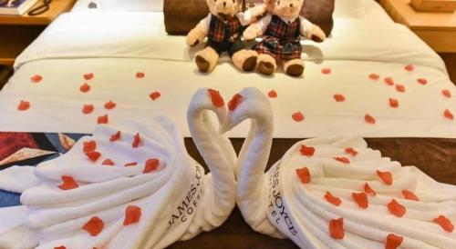two towels shaped like swans sitting on a bed at James Joyce Coffetel· Xianyang Renmin Road Central Square Store in Xianyang