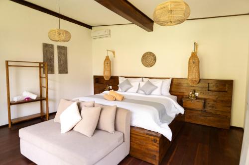 a bedroom with a large bed and a couch at AMAN Villas & SPA in Gili Air