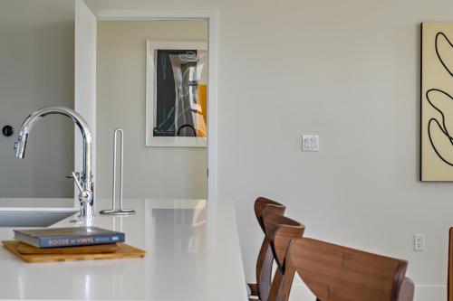 a kitchen counter with a sink and a chair at Lofted Living | Espadin LoHi in Denver
