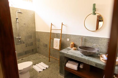 a bathroom with a sink and a shower and a toilet at AMAN Villas & SPA in Gili Air