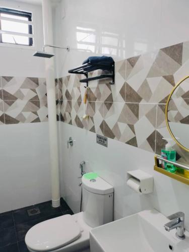 a bathroom with a toilet and a sink and a mirror at Homestay impian, arau in Arau