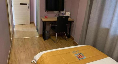 a bedroom with a desk and a bed and a table at PAI Hotels Shijiazhuang Railway Station West Square in Shijiazhuang