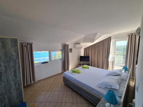 a bedroom with a large bed and a large window at Casa DELL'ARTE in Ahtopol
