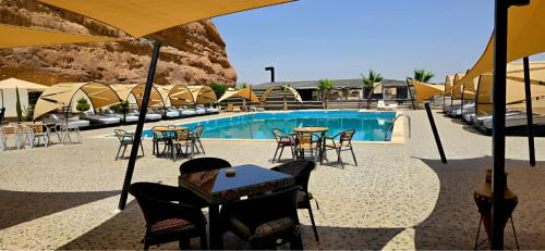 a pool with tables and chairs in front of a building at The bubble camp in Aqaba