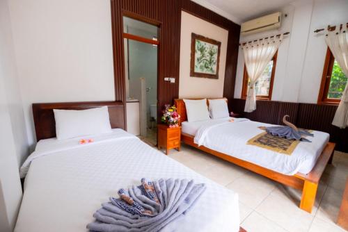 a bedroom with two beds with towels on them at Teba House Ubud by ecommerceloka - CHSE Certified in Ubud