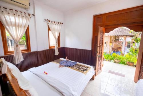 a bedroom with a bed and a window at Teba House Ubud by ecommerceloka - CHSE Certified in Ubud