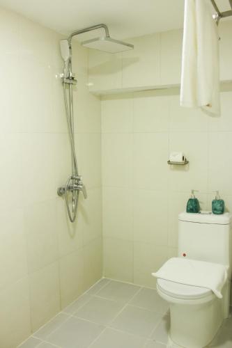 a white bathroom with a toilet and a shower at Le Petit Hotel & Travel in Hanoi