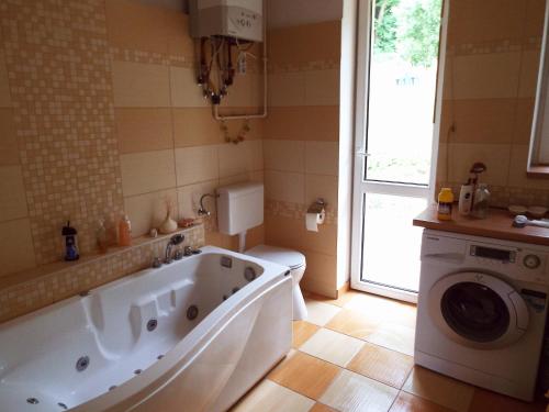 ein Badezimmer mit einer Badewanne und einer Waschmaschine in der Unterkunft Villa Panorama Artist in Dömös