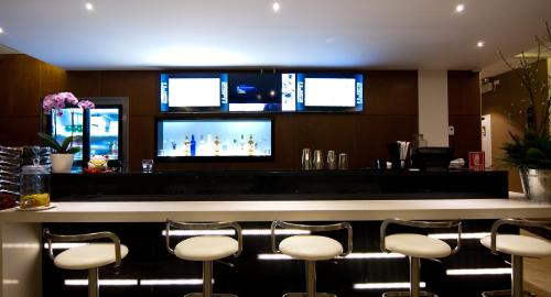 a bar with white bar stools in a restaurant at Lyz Business Hotel in Lima