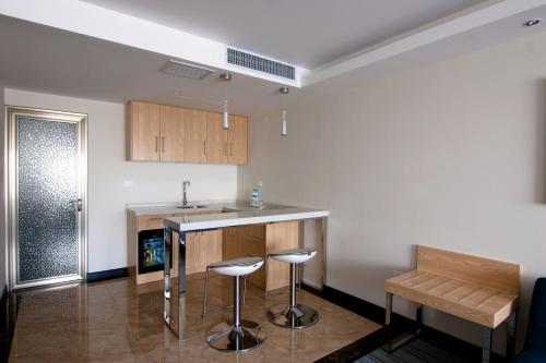 a kitchen with a counter and stools in a room at Lyz Business Hotel in Lima