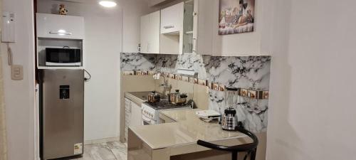 a kitchen with white cabinets and a refrigerator at Kallpa in Cusco