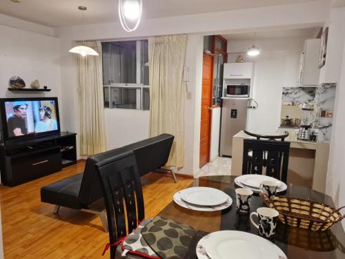 a living room with a dining table and a kitchen at Kallpa in Cusco