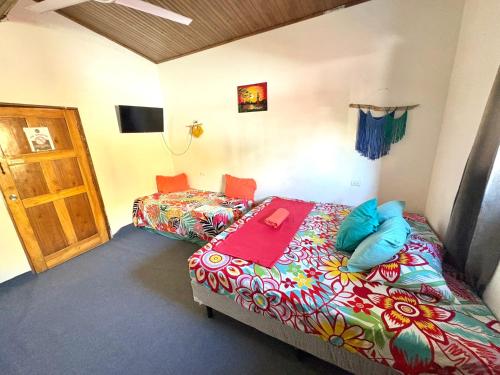 a bedroom with two beds and a door in it at Cheap Hostel Quepos in Quepos