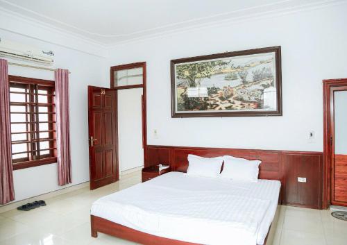 a bedroom with a bed and a painting on the wall at Trường Yến Hotel Ninh Bình in Ninh Binh
