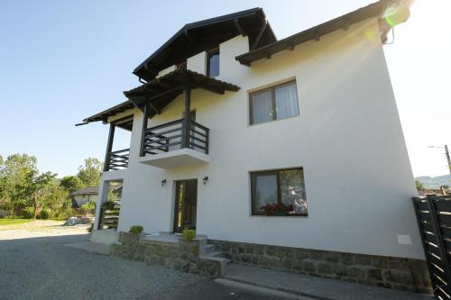 a white house with a balcony at Casa Timiș in Vişeu de Sus