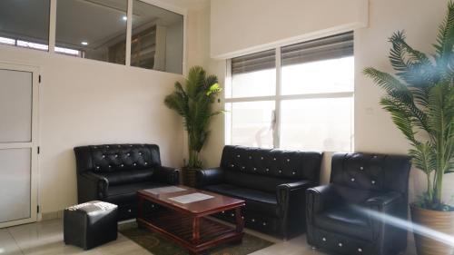 a waiting room with two black leather couches and a table at Hôtel Moukawama Restaurant & SPA Dakhla in Dakhla