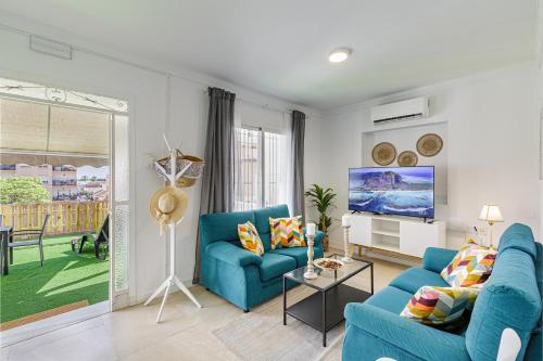 a living room with a blue couch and a tv at Stay Belonio El Palo Beach in Málaga