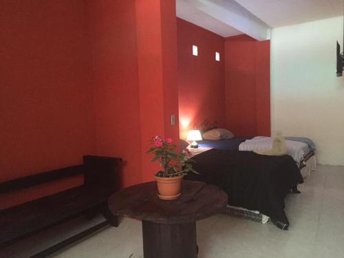 a bedroom with a bed and a table with a potted plant at Alojamiento D'Rosales in Cobán