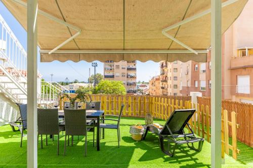 a patio with a table and chairs on the grass at Stay Belonio El Palo Beach in Málaga