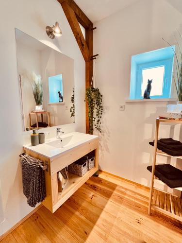 une salle de bain avec un lavabo et un miroir dans l'établissement chambres d'hôtes Domaine les Grands Pérons, à Hérisson