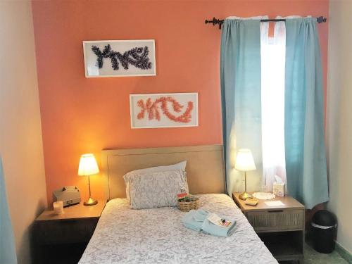 Un dormitorio con una cama y dos lámparas y una ventana. en 1 Cozy Private Room in San Juan with Garden View, en San Juan