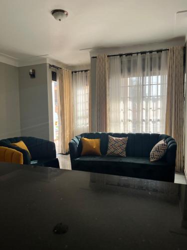 a living room with a blue couch and a window at Comfy Urban Haven in Nalakonge