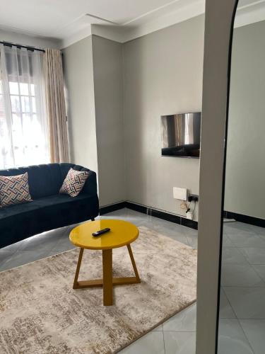 a living room with a table and a couch at Comfy Urban Haven in Nalakonge