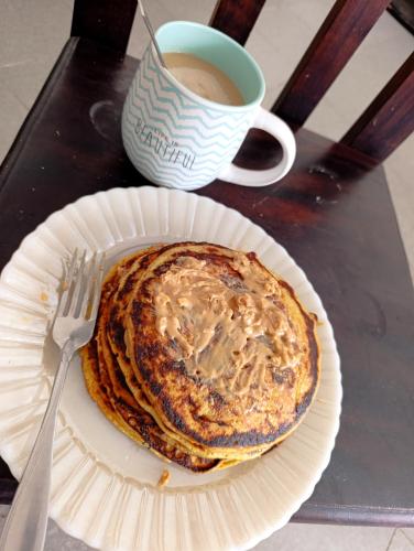 a stack of pancakes on a paper plate with a cup of coffee at Arizpe Roommate in Irapuato