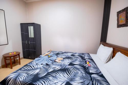 a bedroom with a bed with a blue comforter at Teba House Ubud by ecommerceloka - CHSE Certified in Ubud