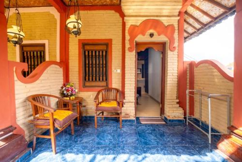 a porch of a house with two chairs and a table at Teba House Ubud by ecommerceloka - CHSE Certified in Ubud