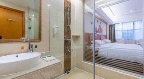 ein Bad mit einer Badewanne und einer Dusche sowie ein Bett in der Unterkunft Vienna Hotel Hunan Shaoyang South Railway Station in Shaoyang