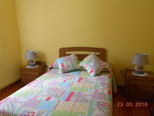 a bedroom with a bed with two nightstands and two lamps at Hotel Alto de las Estazadas in Canales